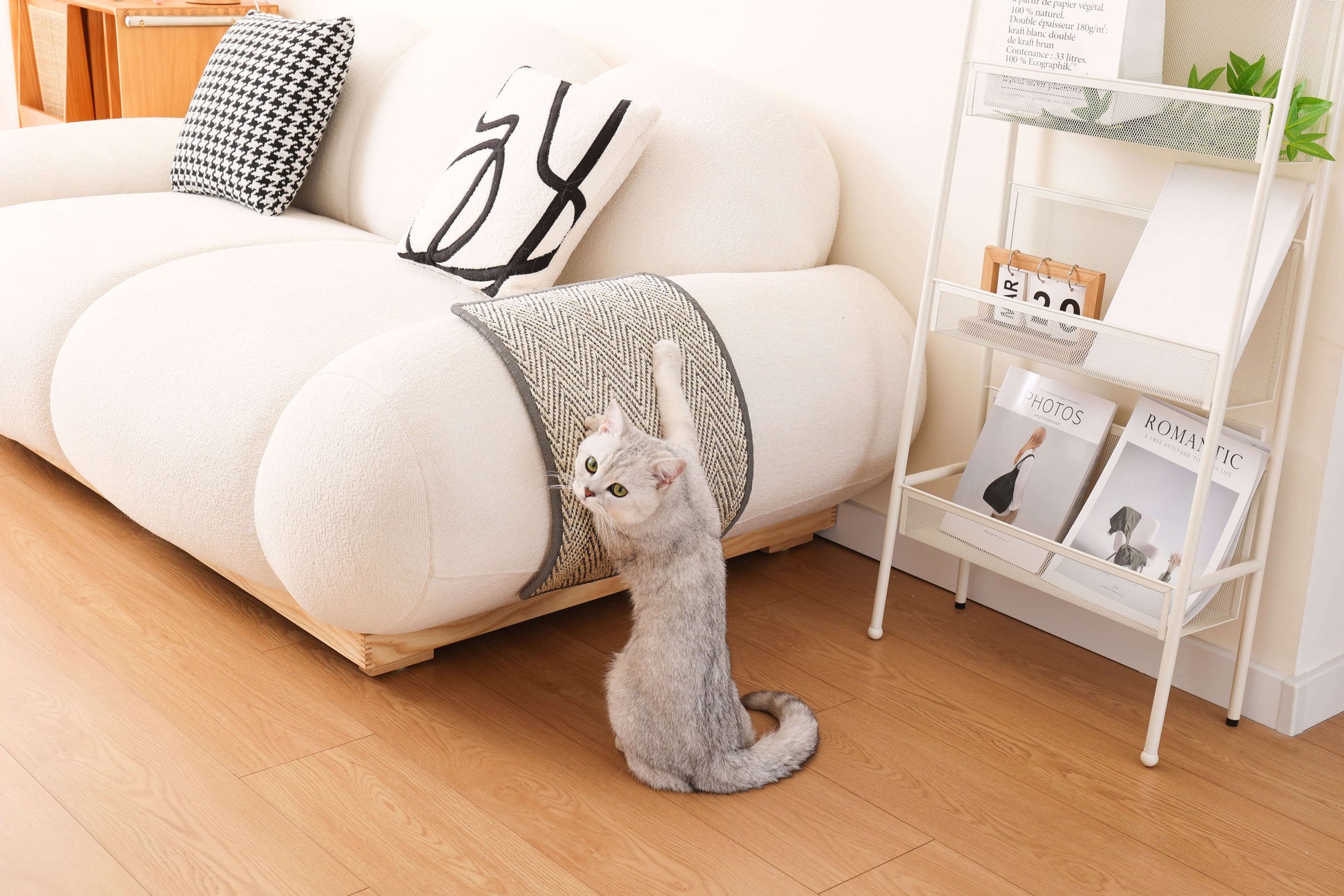 Cat using a Boho-Style Natural Sisal Scratching Mat attached to a sofa in a stylish living room.