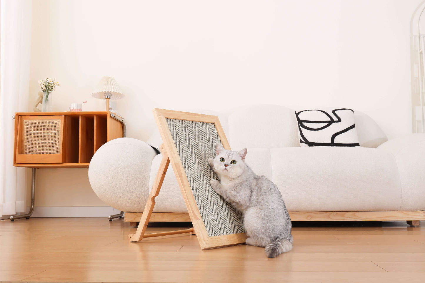 Cat using boho-style natural sisal scratching mat in a cozy living room setting.