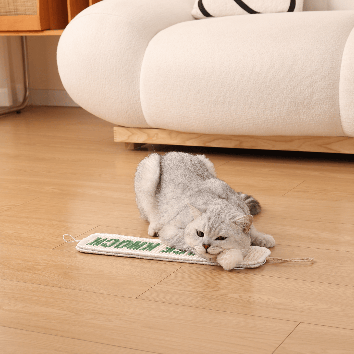 Cat playing on Furrther's 3-in-1 Hanging Sisal Scratch Mat next to a white sofa, enjoying its versatile scratching features.